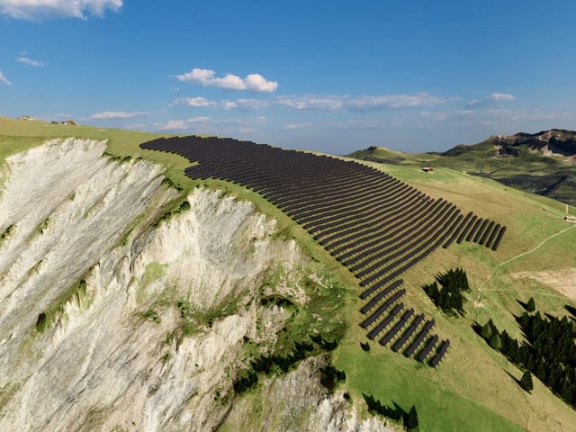 Grüner Berg mit Solaranlagen