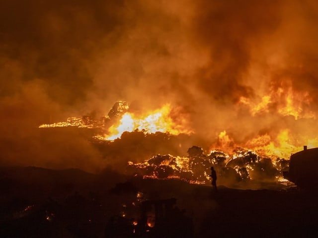 Grossbrand in einer Industrieanlage bei Nacht.