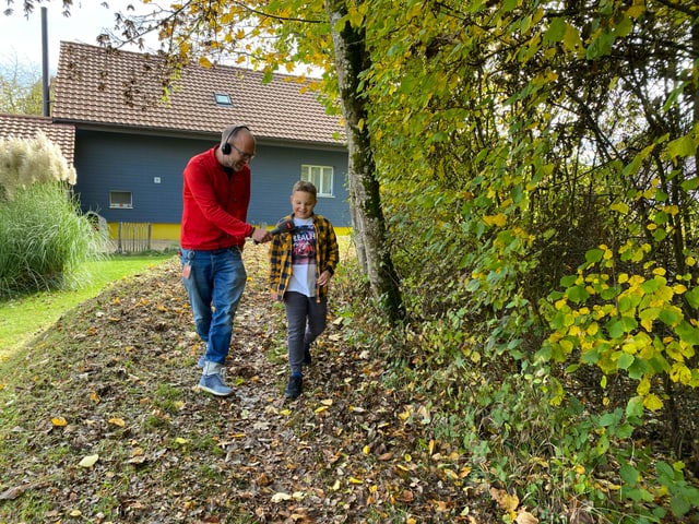 Noa und Reto spazieren durch den Wald.