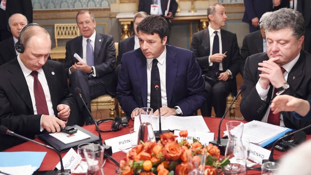 Wladimir Putin, Matteo Renzi und Petro Poroschenko sitzen an einem Tisch.