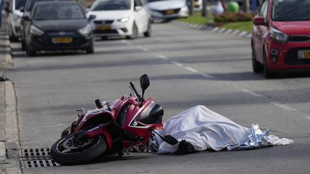 Zugedecktes Todesopfer neben Motorrad.