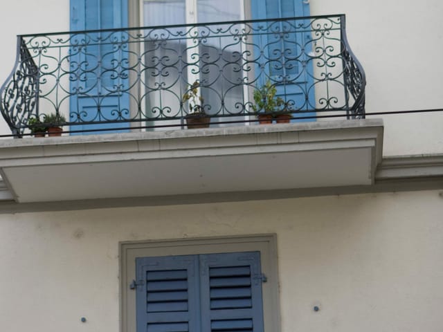 Ein Haus mit offenen und geschlossenen Fensterläden