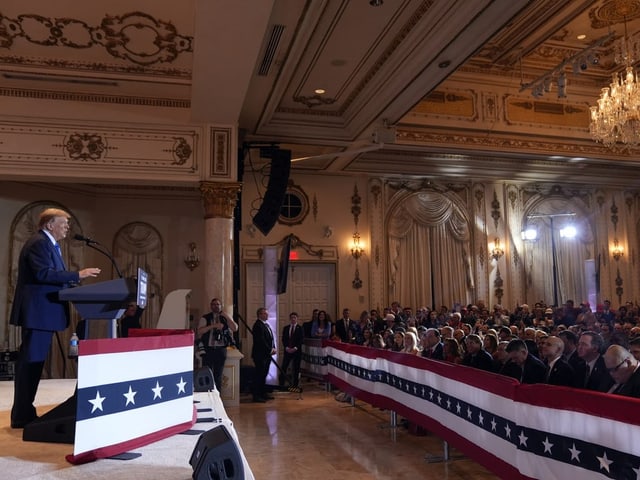 Trump steht auf der Bühne vor seinen Fans. 