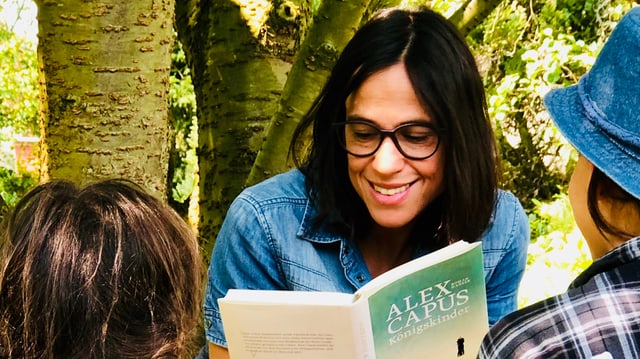 Annette König liest ihren Kindern aus Alex Capus «Königskinder» vor. Und sitzt dabei unter einem Baum im Grünen