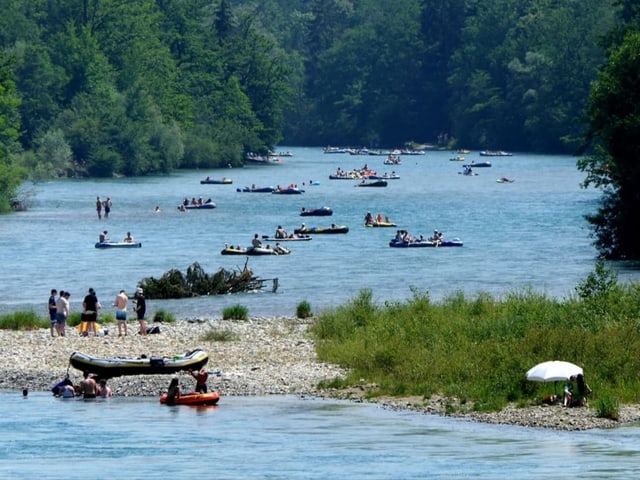 Aare mit vielen Gummibooten an sonnigem Sommertag.