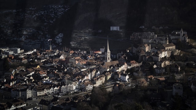 Stadtansicht bei Tageslicht mit Kirche und Gebäuden im Vordergrund.