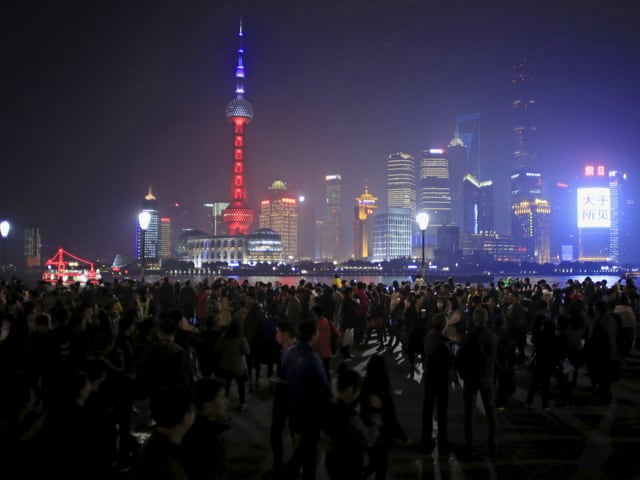 Der Oriental Pearl Tower in Shanghai leuchtet blau, weiss, rot