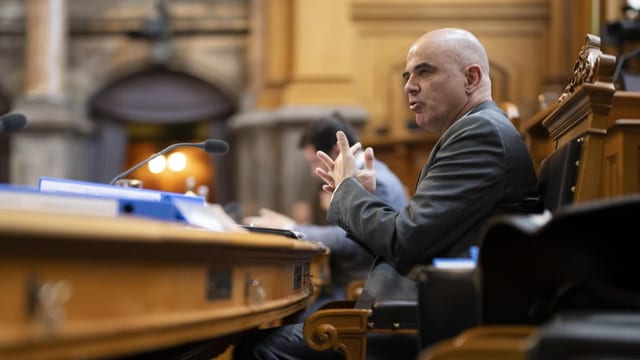 Bundespräsident Alain Berset sitzt an einem Pult im Nationalratssaal.