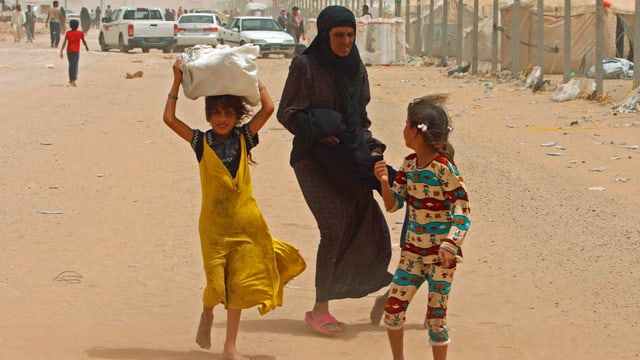 Frau mit Kindern auf der Flucht.