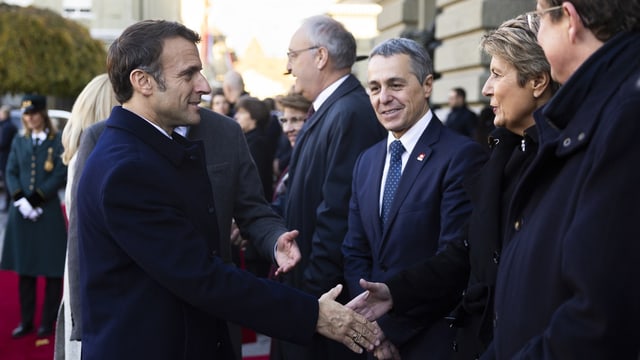 Macron und Keller-Sutter geben sich die Hand. Weitere Bundesräte stehen neben ihnen.