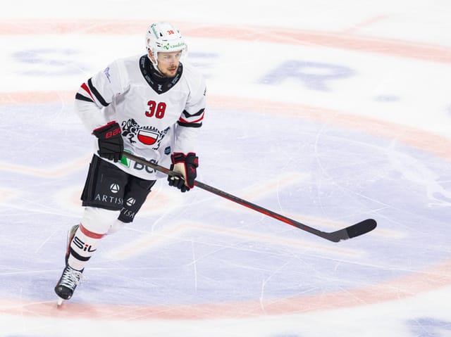 Eishockeyspieler in weissem Trikot auf dem Eis.