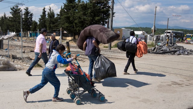 Flüchtlinge schleppen ihre Habseligkeiten