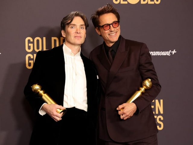 Cillian Murphy (links) und Robert Downey  vor einem Plakat.