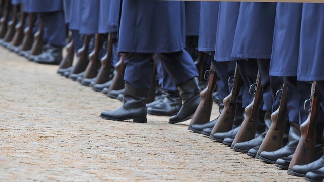 Ein Fuss schert in stramm stehenden Soldaten aus. 