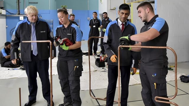 Boris Johnson und Rishi Sunak lassen sich an der British Gas Training Academy etwas erklären.