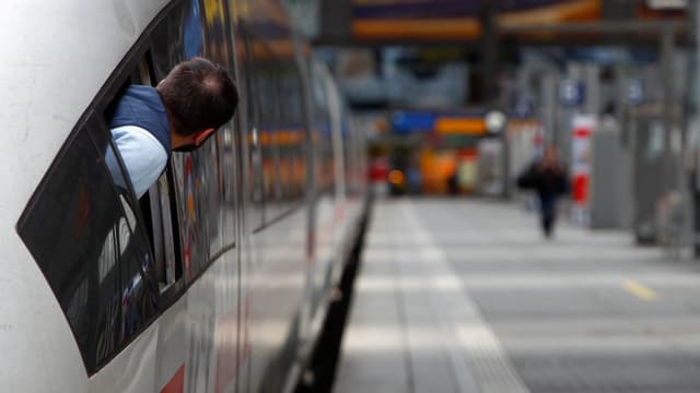 Lokführer schaut aus stehendem Zug heraus