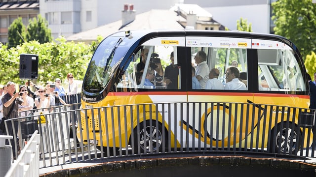 Ein Mini-Postauto auf einer Brücke.