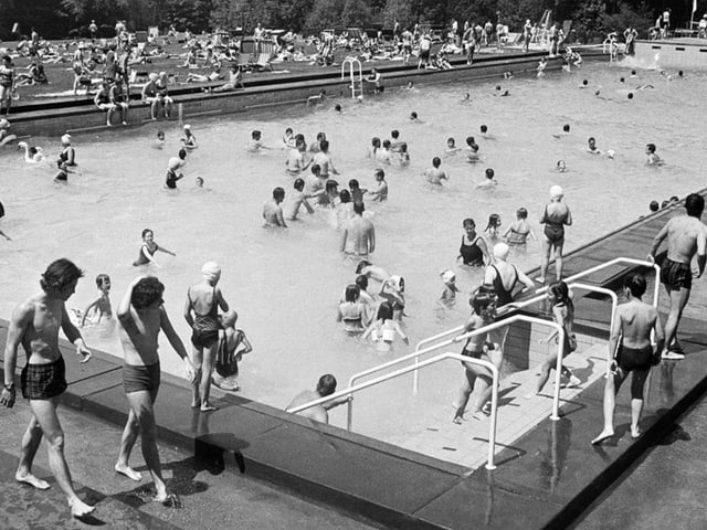 Schwarzweiss-Foto von Menschen im Freibad.