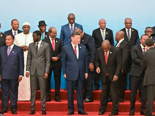 Gruppenfoto von Regierungsvertretern auf einer roten Treppe.