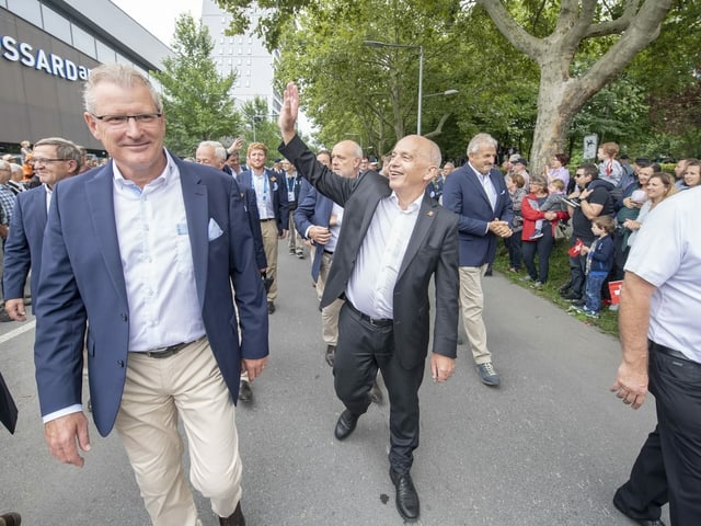 Maurer winkt Zuschauenden am Festumzug zu. 