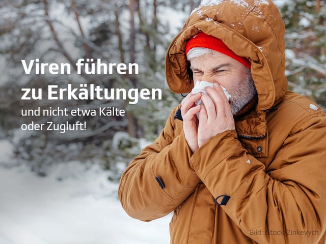 Mann mit brauner Jacke schneutzt Nase im Schnee.