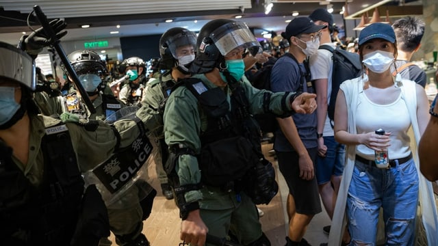 Police clear a shopping center in Hong Kong.