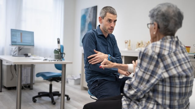 Eine Patientin und ein Arzt während einer Sprechstunde in einer Hausarztpraxis.