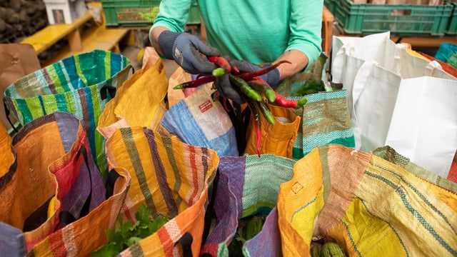 Bunte Taschen, in der vordersten sieht man eine gelbe Zuchetti und eine organge Peperoni.