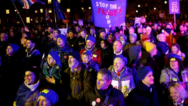 Leute stehen bei Nacht beeinander.