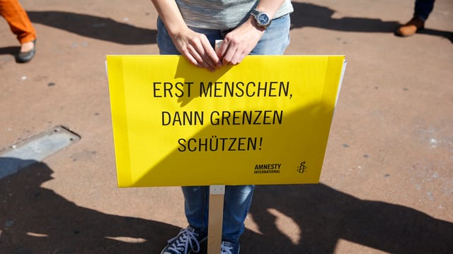 Ein Plakat «Erst Menschen, dann Grenzen schützen!»