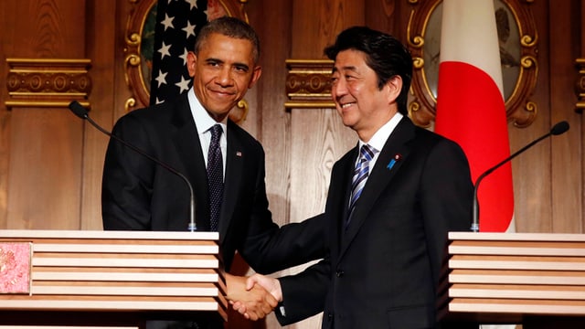 US-Präsident Obama und der japanische Premier Abe schütteln sich an einer Medienkonferenz die Hände.