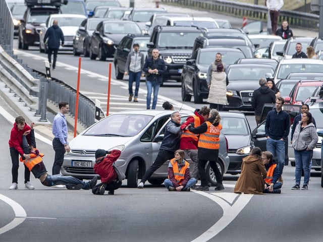 Leute blockieren die Strasse.