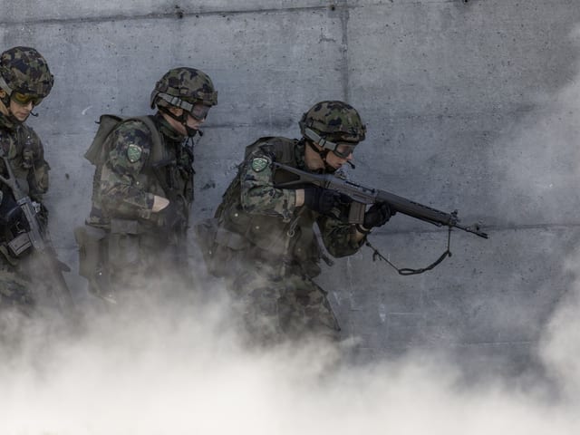 Soldaten in Tarnkleidung mit Waffen in Nebel