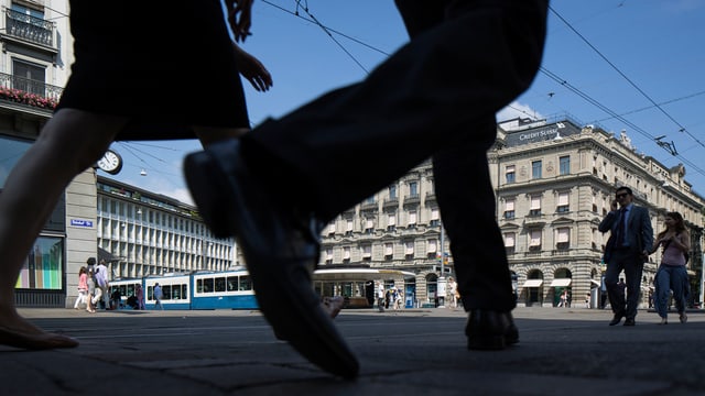 Zwei Leute gehen über den Zürcher Paradeplatz.