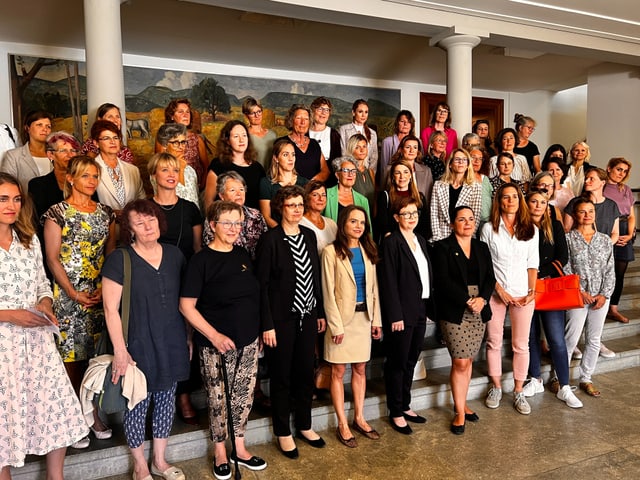 Eine Gruppe von Frauen steht auf einer Treppe. 