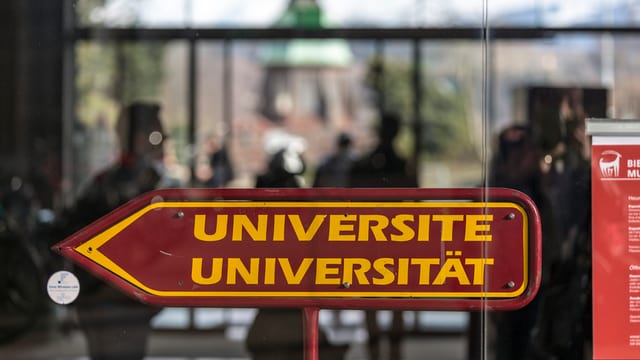 Ein Pfeil, zweisprachig angeschrieben, weist den Weg zur Universität.