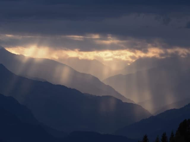 Dunkle Wolken und leuchtende Sonnenstahlen. 