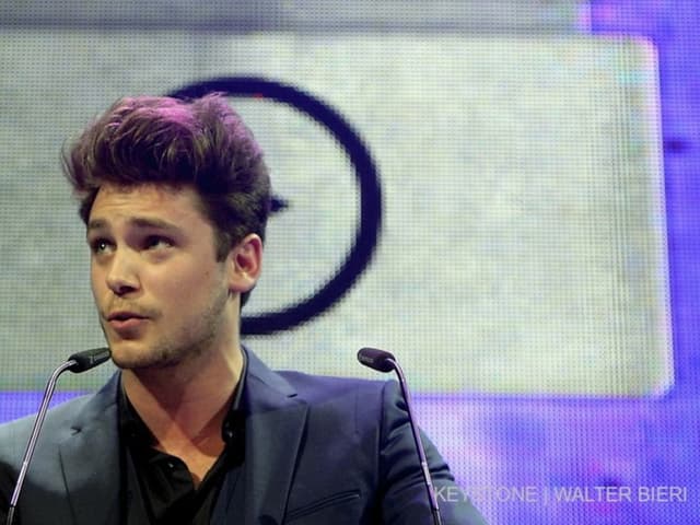 Bastian Baker mit SMA-Logo im Hintergrund