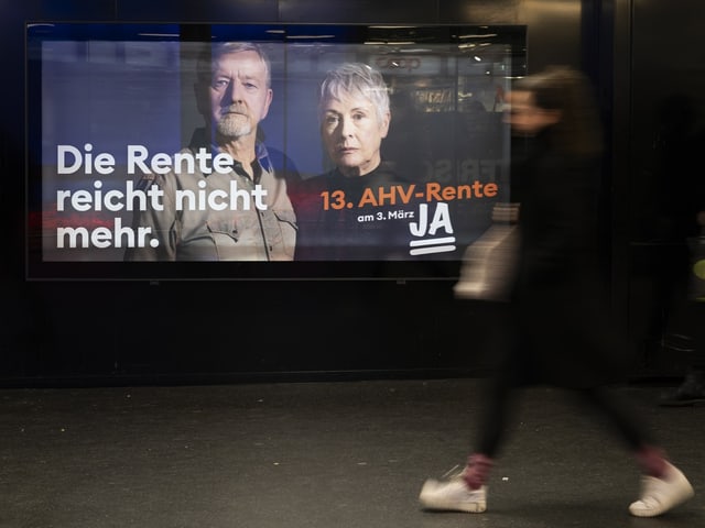 Eine Frau läuft an einem Ja-Plakat zur 13. AHV-Rente vorbei.