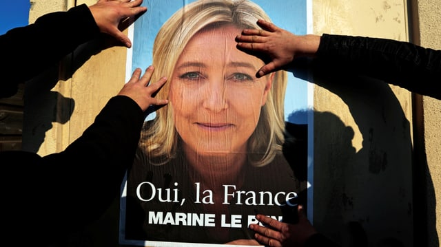 Unterstützer kleben Wahlplakate für Marine Le Pen in Frankreich. 