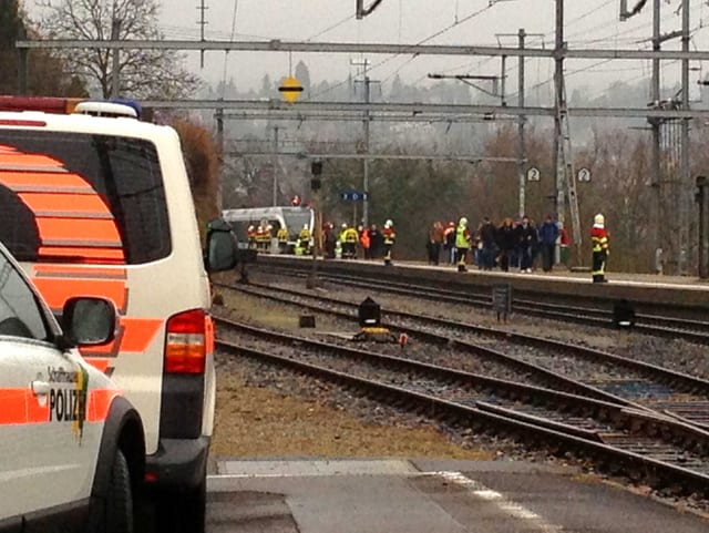 Polizisten stehen auf dem Unfallgelände.