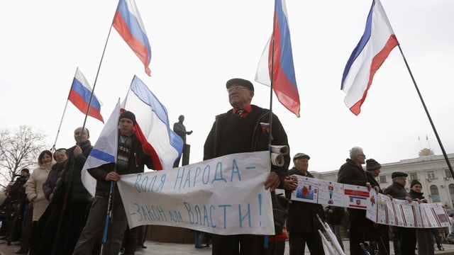 Demonstranten mit russischen Flaggen demonstrieren.