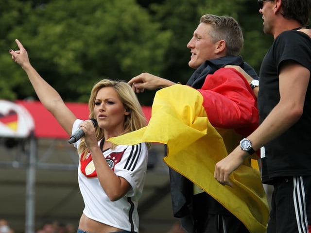 Frau und Mann jubeln bei Fussballveranstaltung in Deutschlandtrikots.