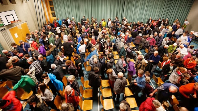 Menschen drängen sich in einer Turnhalle