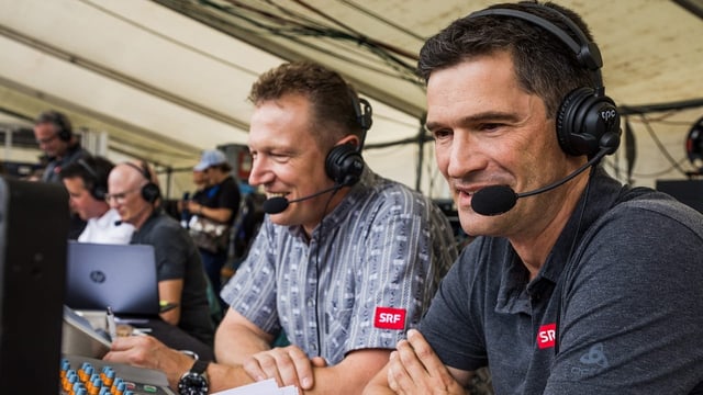 Adrian Käser und Stefan Hofmänner sitzen in der Medienzone. Sie tragen Headsets und blicken auf Bildschirme.