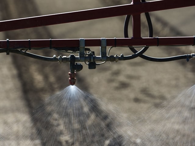 Bewässerungssystem beim Versprühen von Wasser über ein Feld.