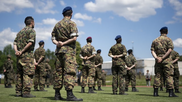 Militärangehörige stehen auf einem Feld