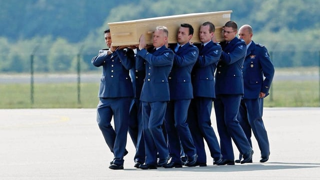 Soldaten tragen einen Sarg auf ihren Schultern.