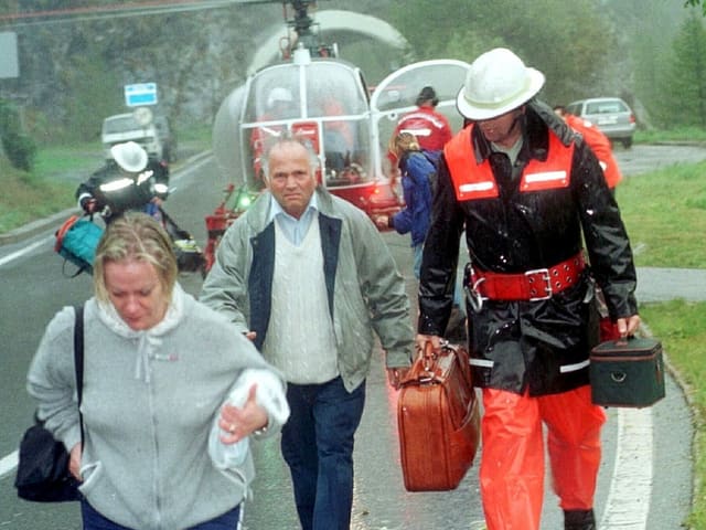 Personen mit Koffern evakuiert