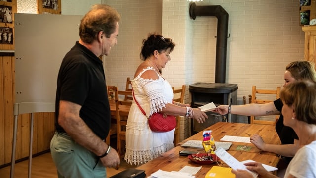 Personen in einem Wahllokal in Brandenburg